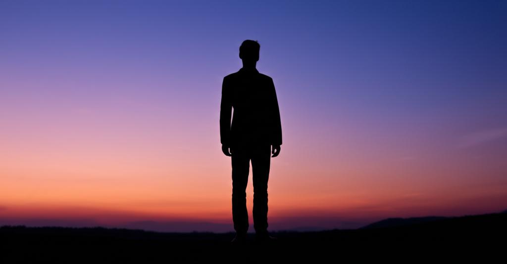 Man sitting alone looking stressed and tired, feeling the weight of expectations